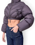Lost Labels Khaite cropped puffer jacket in dark grey with a high collar, zip-up front, and modern silhouette.