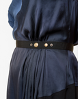 Lost Labels Nina Ricci navy silk dress featuring a fluid drape and a black elasticated waist belt with metal buttons.