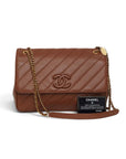 Lost Labels brown leather Chanel flap bag with diagonal quilting, gold chain strap, and authenticity card.