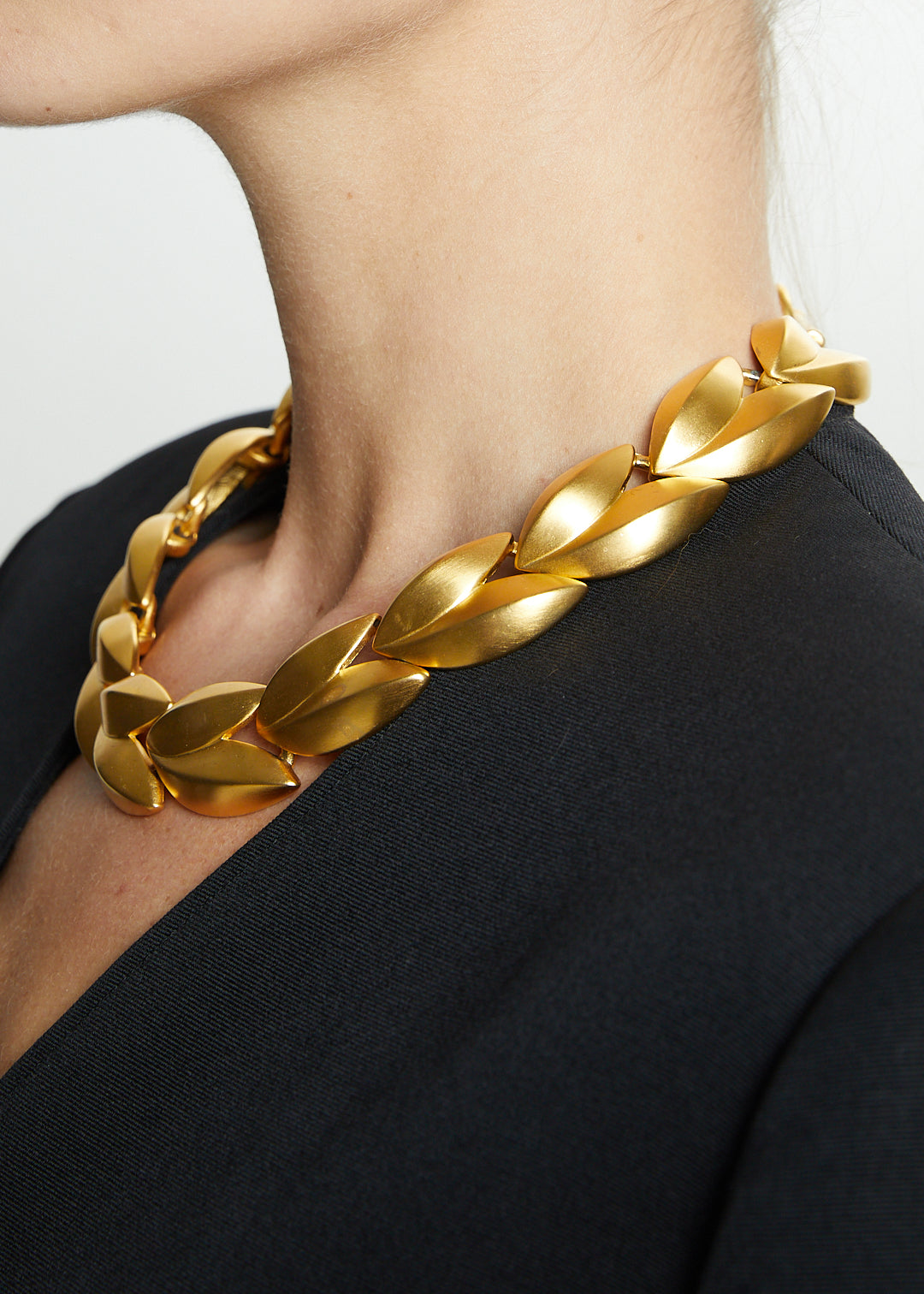 Lost Labels Givenchy statement necklace featuring brushed gold-tone sculptural leaf links worn around the neck.