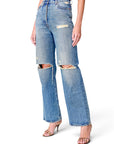 Lost Labels Gucci blue denim jeans with distressed knee rips and a straight-leg fit worn by a model.