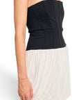 Lost Labels Jonathan Simkhai strapless mini dress with a black corset bodice and a pleated cream bubble skirt.