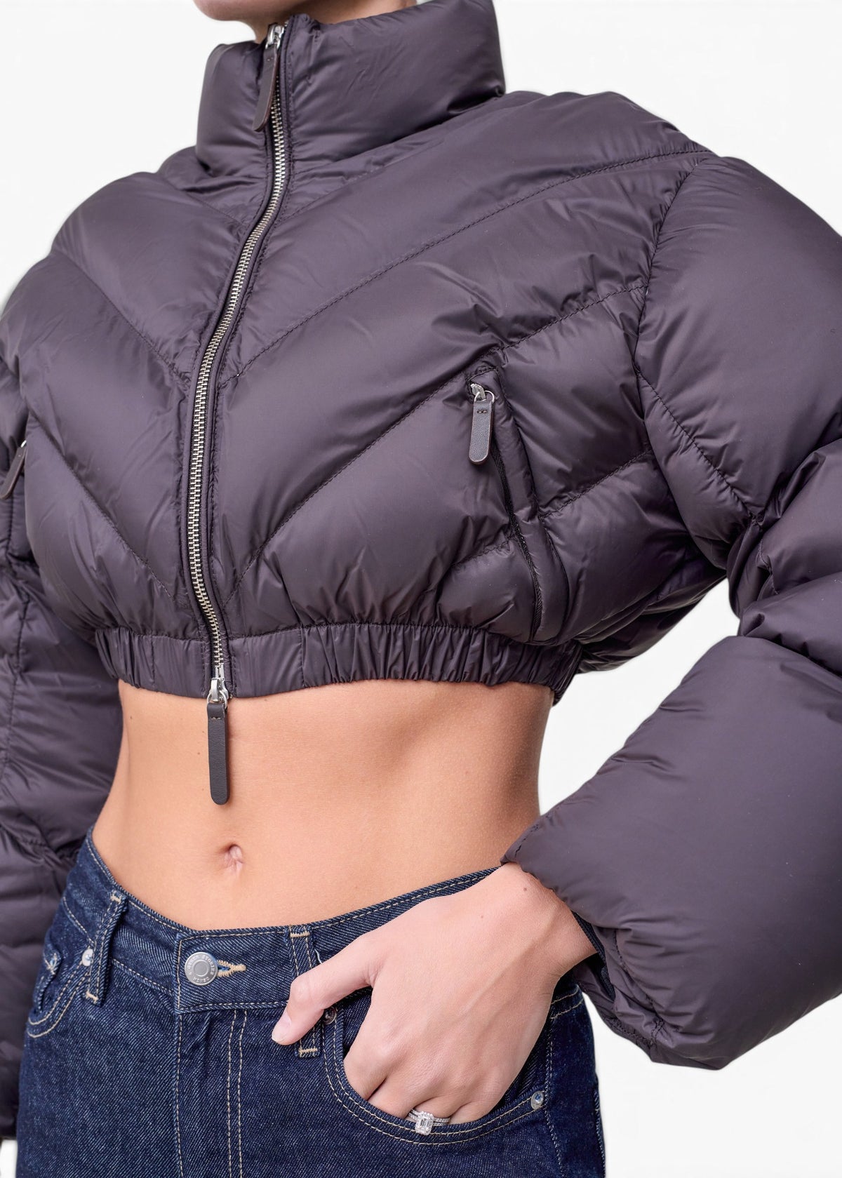 Lost Labels Khaite cropped puffer jacket in dark grey with chevron quilting, high collar, and silver zip closure.