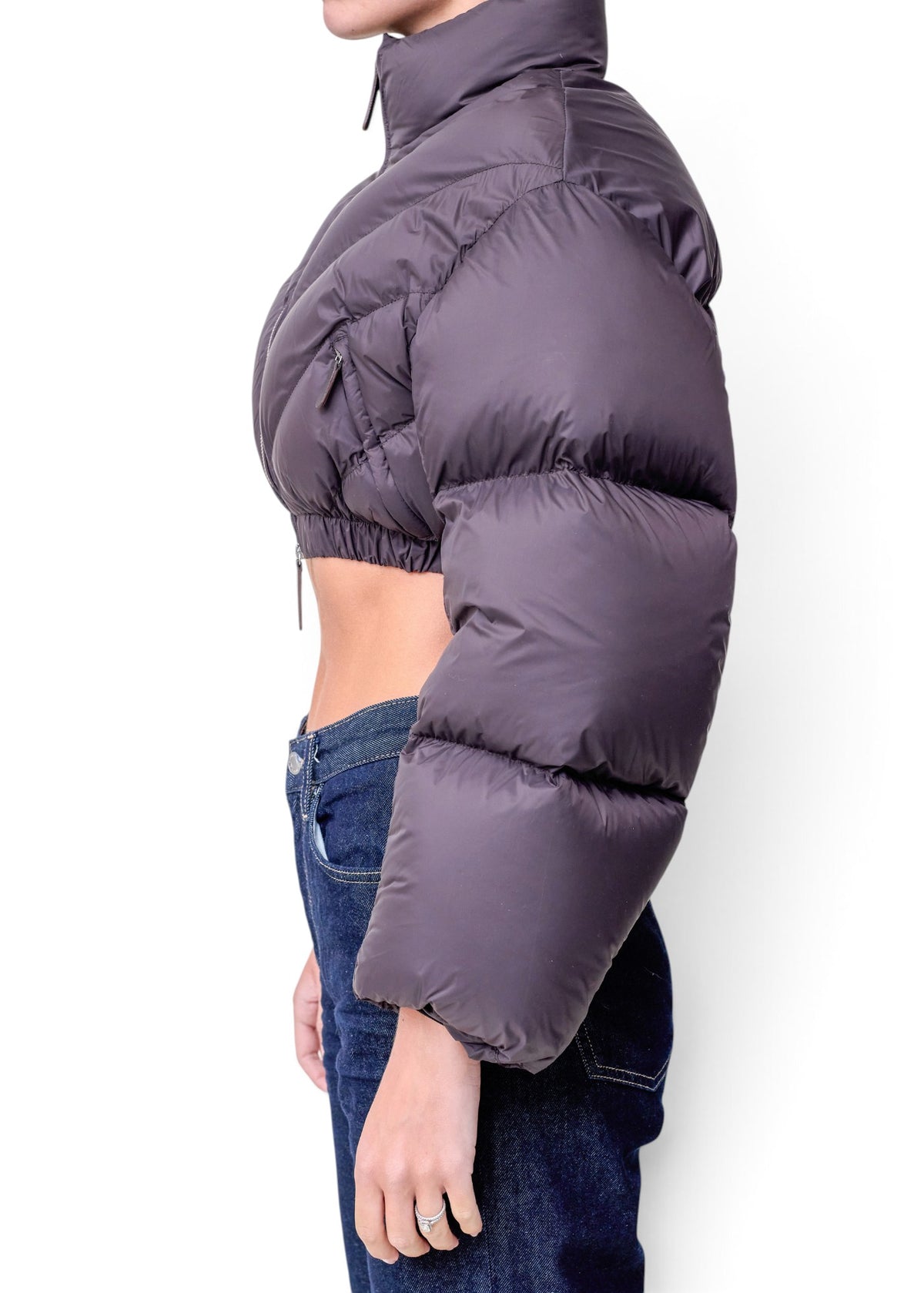 Lost Labels Khaite cropped puffer jacket in dark grey worn with blue jeans, side profile view