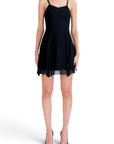 Lost Labels Versus Versace black mini dress with thin straps and a flared skirt, worn by a model on white background.