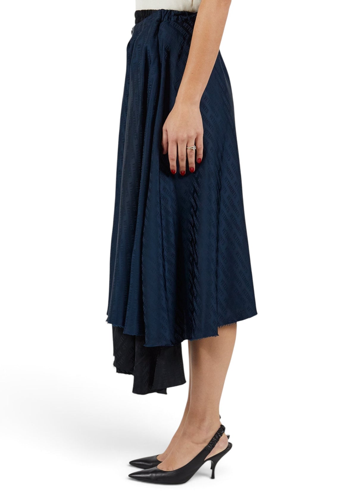 Lost Labels Vetements reversible black and navy midi skirt with all-over logo print worn by a model in black heels.