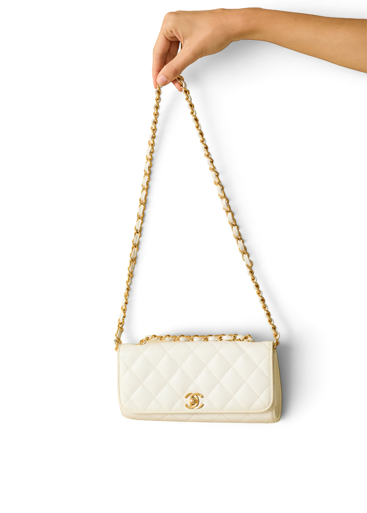 Lost Labels white quilted leather Chanel bag with gold chain strap held by a hand against a white background.